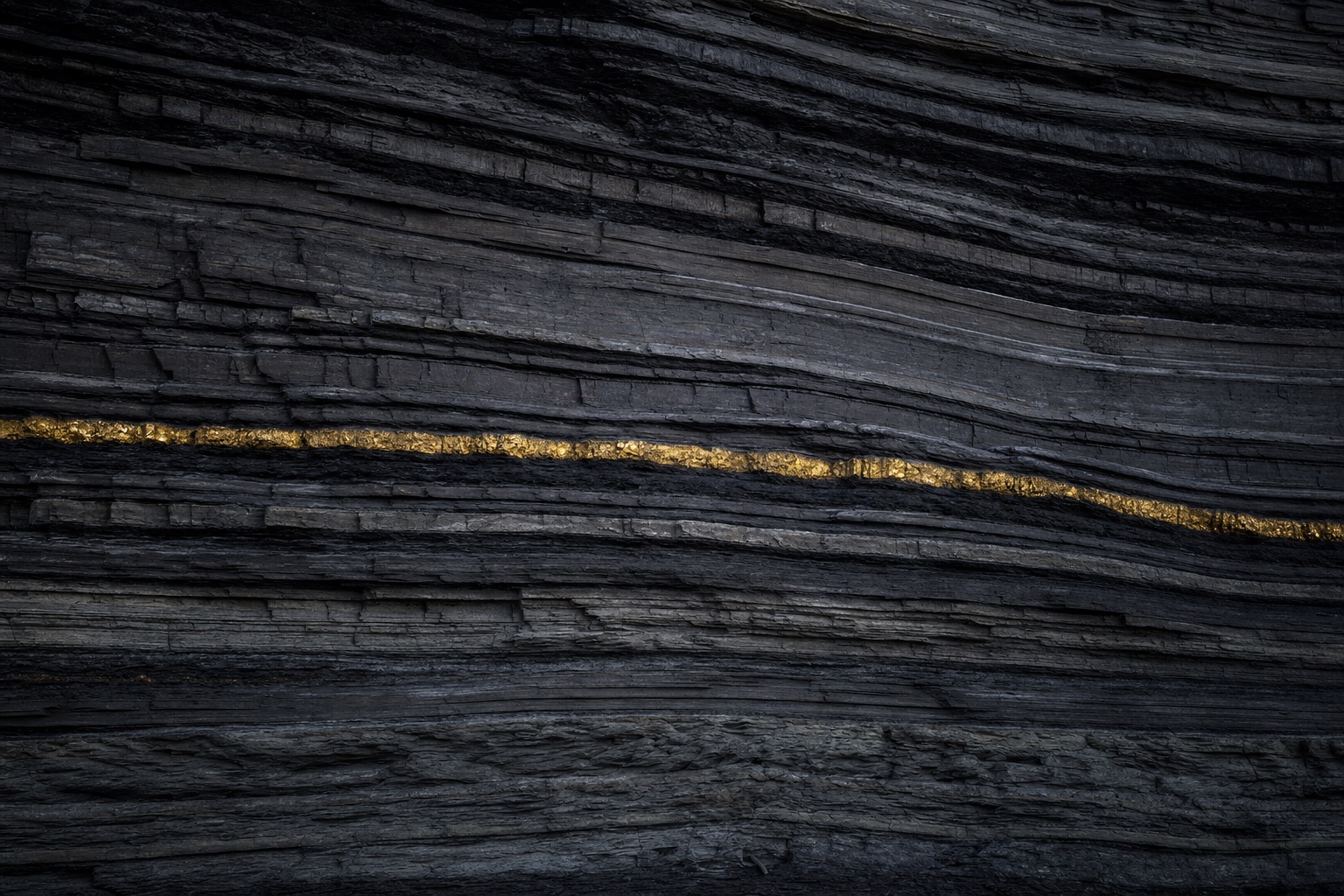 Layered rock strata with a continuous brass-gold mineral seam